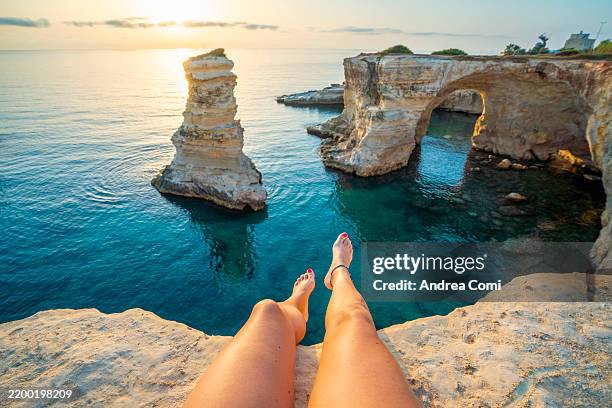 personal perspective of woman enjoying the view at faraglioni di sant'andrea, puglia, italy - wonderlust imagens e fotografias de stock