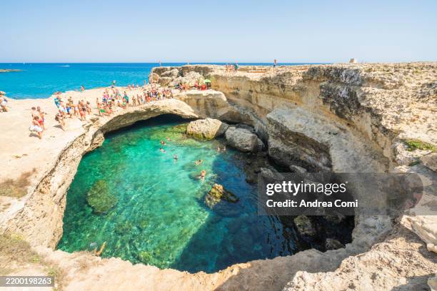 natural pool in salento with crystal waters and adventurous cliff divers puglia - grotte stock-fotos und bilder
