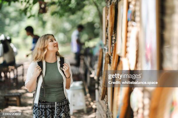 tourists admiring local art works while walking through the open gallery - meaningful stock pictures, royalty-free photos & images