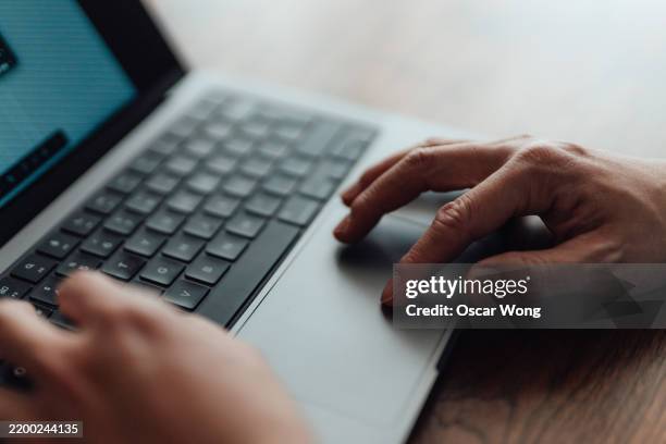 close-up of hands using trackpad typing on a laptop computer - touchpad foto e immagini stock