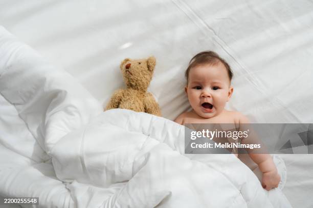 sunny smiles and teddy bear hugs - baby diaper sleeping stock pictures, royalty-free photos & images