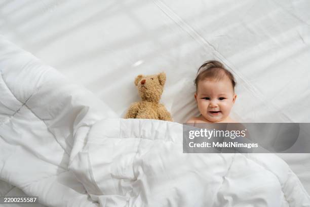 sunny smiles and teddy bear hugs - baby diaper sleeping stock pictures, royalty-free photos & images
