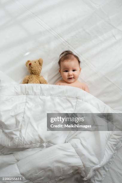 sunny smiles and teddy bear hugs - baby diaper sleeping stock pictures, royalty-free photos & images