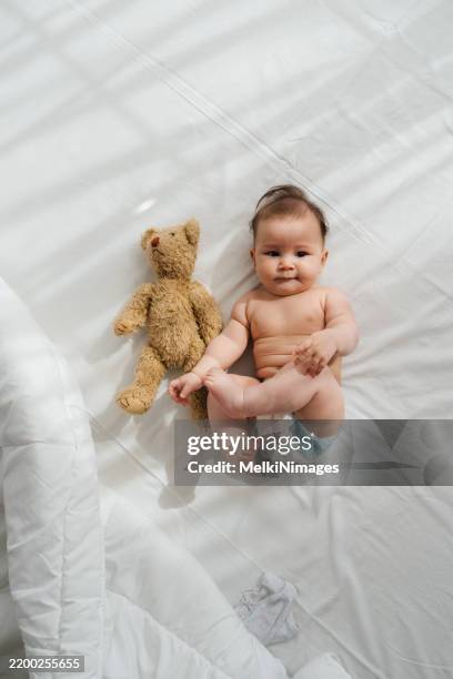 sunny smiles and teddy bear hugs - baby diaper sleeping stock pictures, royalty-free photos & images