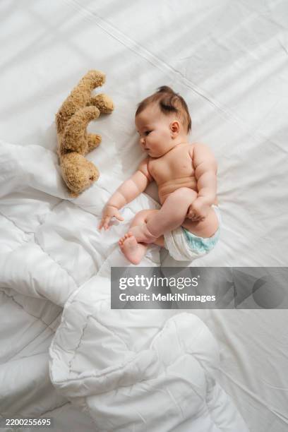 sunny smiles and teddy bear hugs - baby diaper sleeping stock pictures, royalty-free photos & images