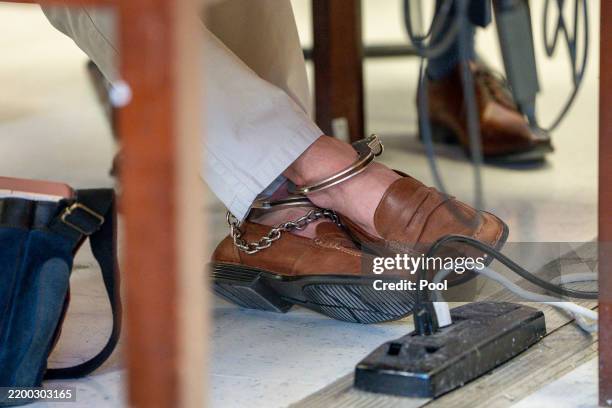 View of the ankle cuffs and shoes worn by Luigi Mangione as he attends a hearing at Manhattan Criminal Court on February 21, 2025 in New York City....