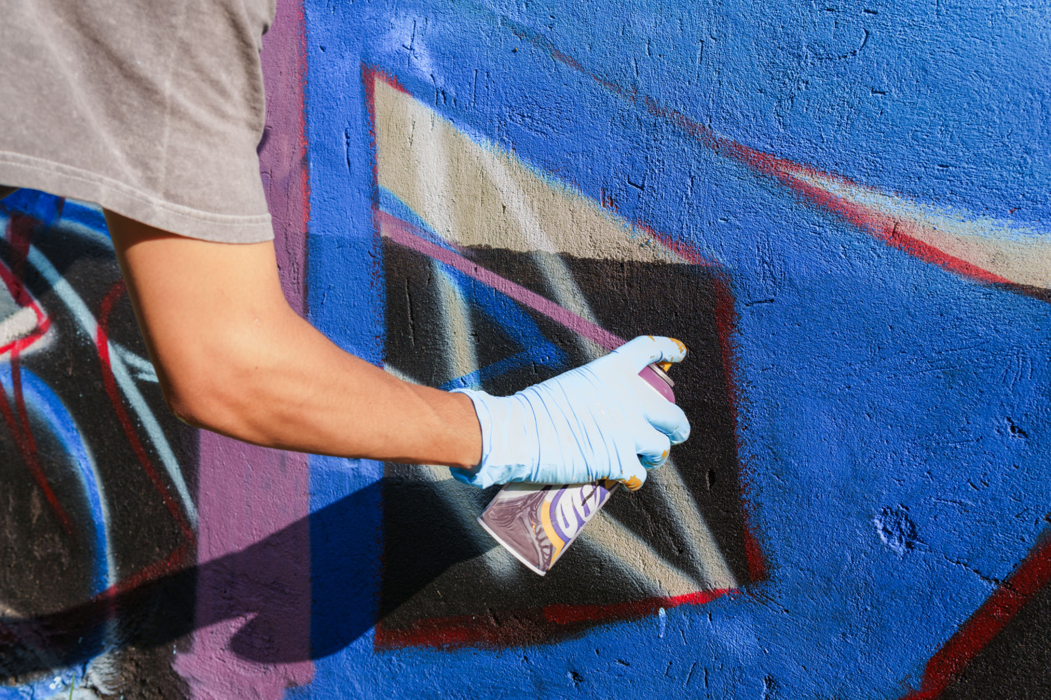 Spraydosen im Einsatz bei professionellen Graffiti Auftragsarbeiten – Detailaufnahme mit kräftigen Farben Spraydosen im Einsatz bei professionellen Graffiti Auftragsarbeiten – Detailaufnahme mit kräftigen Farben