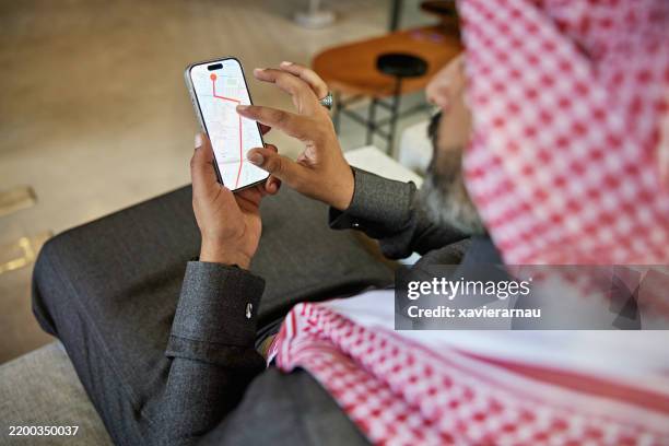 mature businessman checking directions on smart phone - arabian peninsula map stock pictures, royalty-free photos & images