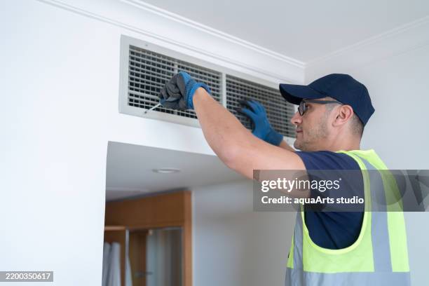 reparador de limpieza de la habitación del hotel ventilación de aire rejilla en la pared - conducto-de-aire fotografías e imágenes de stock