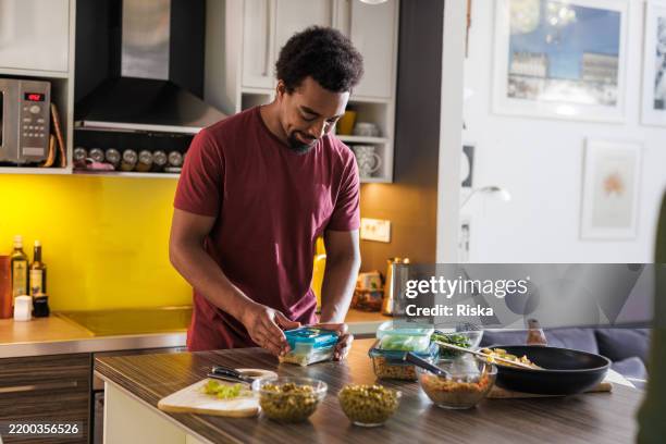 man preparing homemade meals and lunch boxes in a modern kitchen interior - preparing food stock pictures, royalty-free photos & images