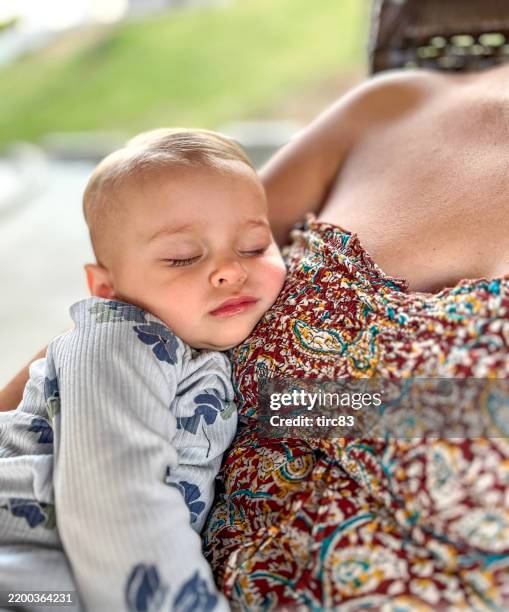 one year old baby girl asleep in mother arms - babyhood stock pictures, royalty-free photos & images