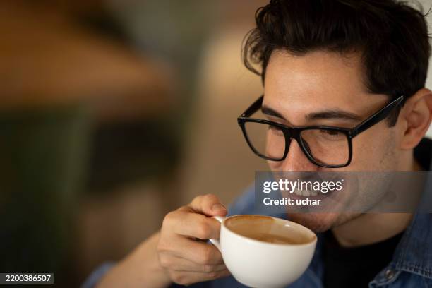 client heureux souriant et buvant du cappuccino dans un café - regarder vers le bas photos et images de collection