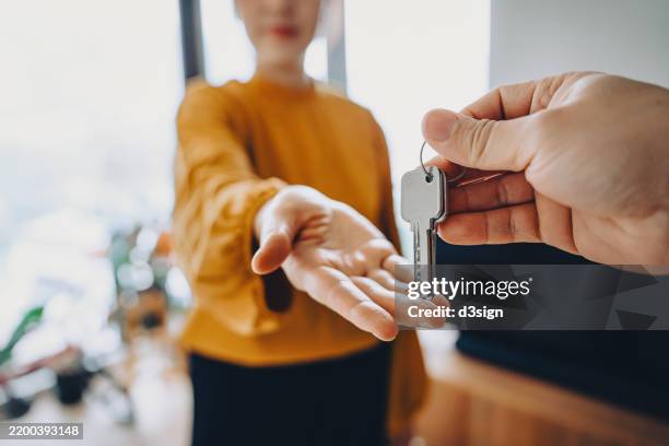 close-up shot of a real estate agent giving a young asian woman the keys to her new home. home ownerships concepts - trasferimento dimmagine foto e immagini stock