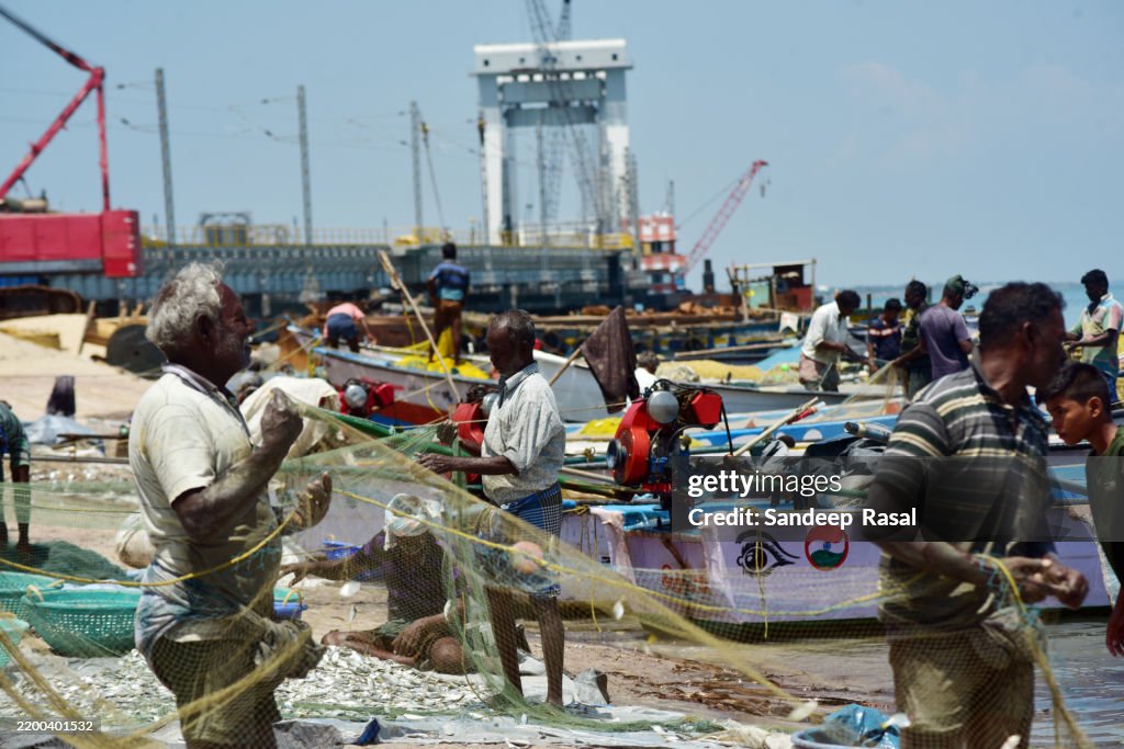 Fishermen removing fresh catch near Old Pamban bridge built in 1914 and on going construction of new Pamban Bridge