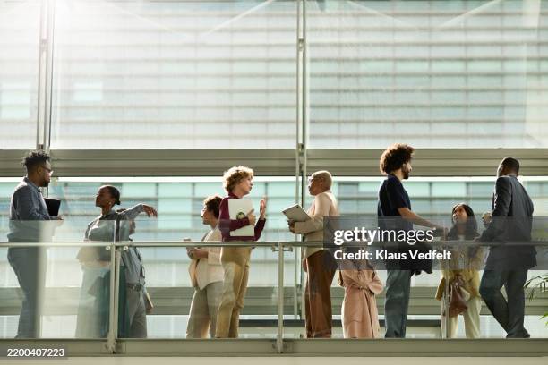 business professionals discussing with each other - bedrijfscultuur stockfoto's en -beelden