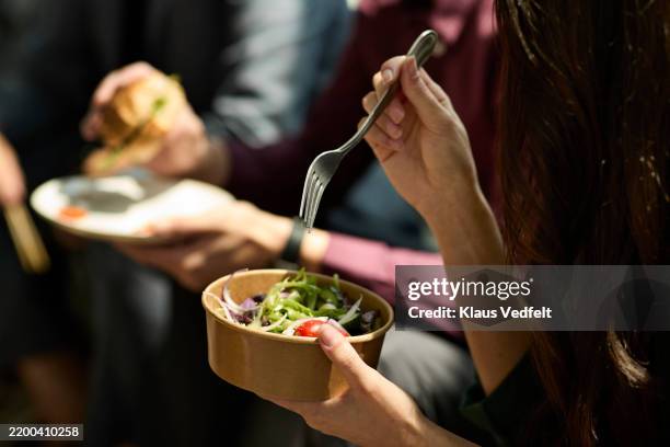 businesswoman eating healthy salad with fork - pausa pranzo foto e immagini stock