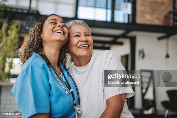 home care healthcare professional hugging elderly patient - nurses laughing stock pictures, royalty-free photos & images