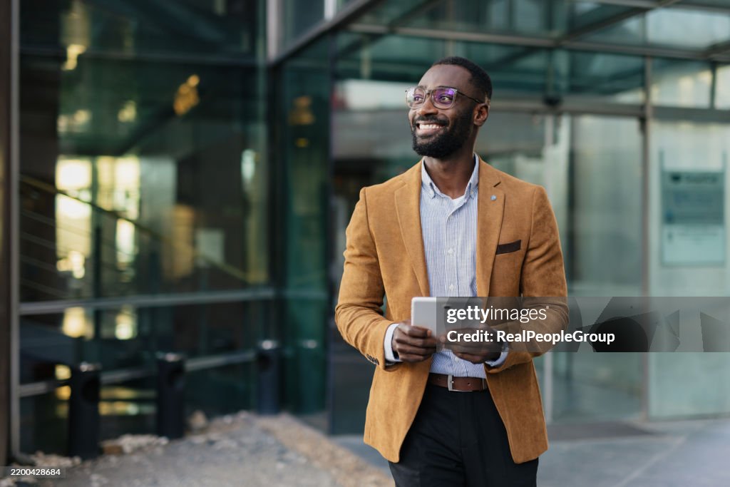 Confident Businessman Holding Tablet in Urban Setting