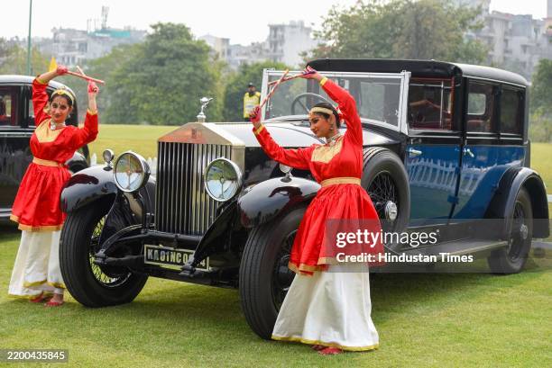 The dancers in traditional dress poses with Rolls-Royce car during the 11th edition of the 21 Gun Salute Concourse at Ambience Golf Greens near...