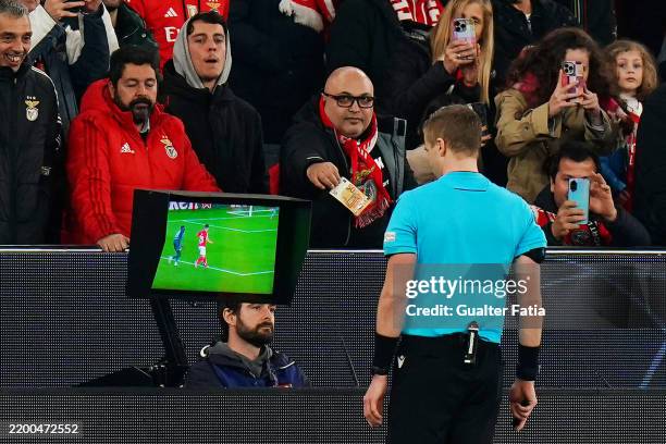 Fan of SL Benfica offers Match Referee, Glenn Nyberg a fifty euro note as he checks the VAR screen during the UEFA Champions League 2024/25 League...