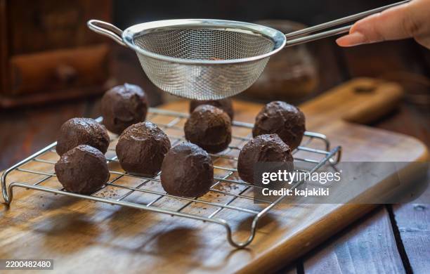 a woman preparing chocolate truffles - chocolate truffle stock pictures, royalty-free photos & images