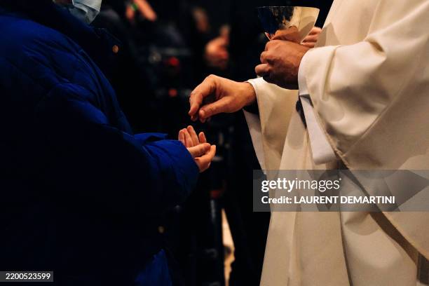 Father Pierre Bertoni gives communion at the Corsican mass held at Notre Dame de Paris, attended by religious faithful and representatives of the...