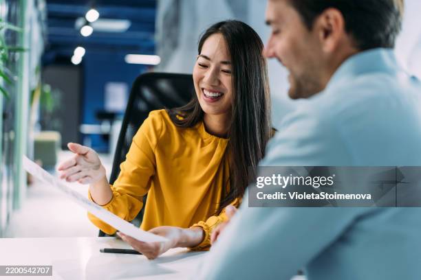 colegas discutiendo el proyecto en el lugar de trabajo. - informe financiero fotografías e imágenes de stock