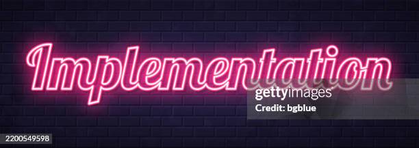 implementation - glowing neon text on brick wall background - light installation stock illustrations