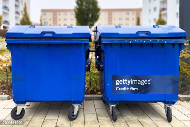 two large blue garbage cans - afvalcontainer stockfoto's en -beelden