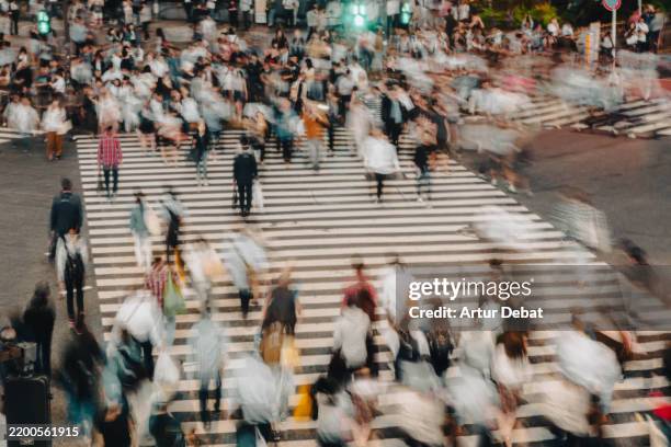 shibuya crossing with blurred people in tokyo - incrocio stradale foto e immagini stock