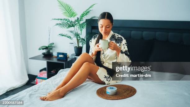 woman at home using shea butter body cream - shea butter stock pictures, royalty-free photos & images