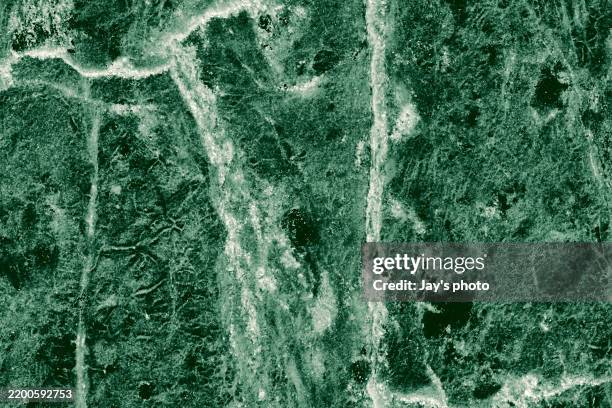 real closeup of dark green marble stone texture surface background. design pattern with high resolution for luxury home decoration. abstract matt slab rock material. front view of natural tiles stone surface. - effet marbré photos et images de collection