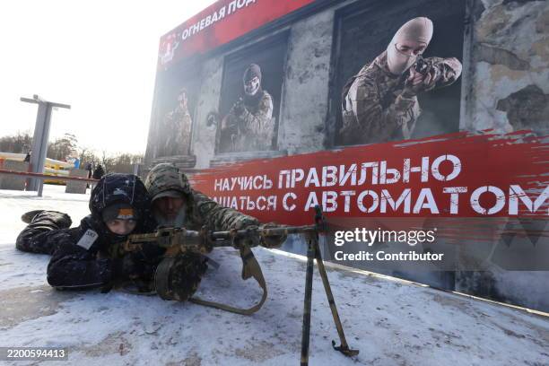 Russian veteran officer assists to a boy to examine an assault rifle during the "Being Healthy is Fashionable", an event, hosted by the...