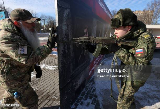 Russian student of the military training center examines an assault rifle during the "Being Healthy is Fashionable", an event, hosted by the...