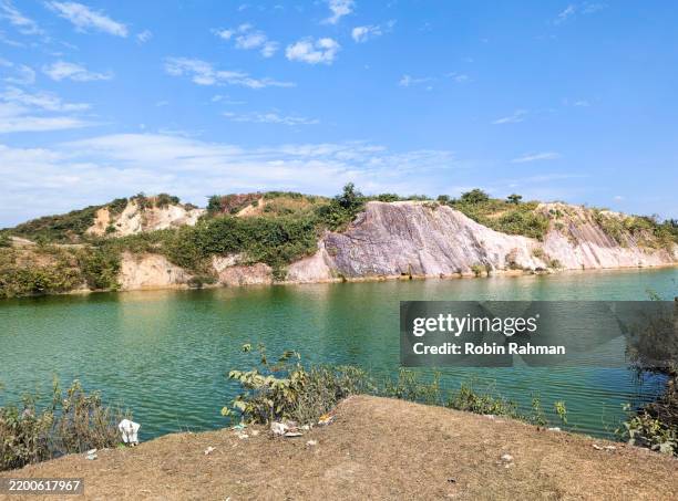 green-water lake with white clay mountains. - netrokona stock pictures, royalty-free photos & images