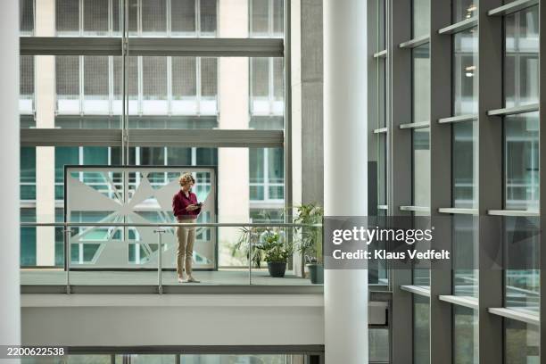 businesswoman using smart phone at office - building atrium stock pictures, royalty-free photos & images