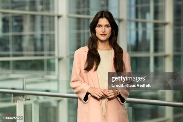businesswoman standing near railing at office - brown hair stock pictures, royalty-free photos & images