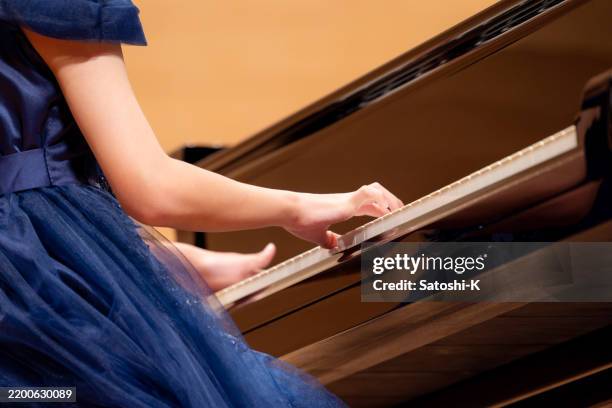 close-up of teenage girl’s hands playing the piano in concert hall - keyboard instrument stock pictures, royalty-free photos & images