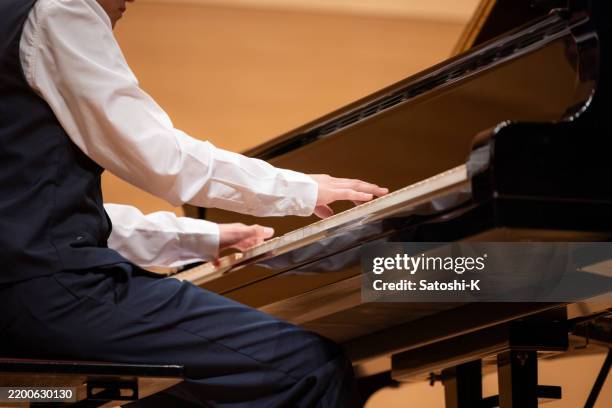 nahaufnahme der hände eines teenagers, der im konzertsaal klavier spielt - konzertflügel stock-fotos und bilder