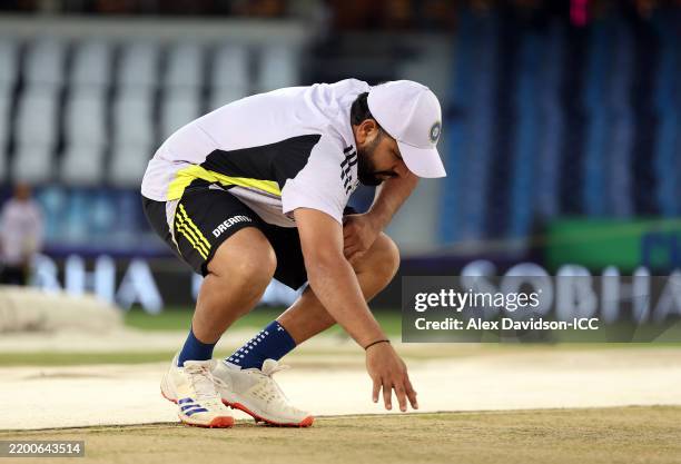 Rohit Sharma of India inspects the pitch during a India Nets Session at Dubai Stadium on February 19, 2025 in Dubai, United Arab Emirates.