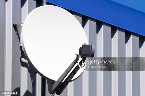 white blank satellite dish on a facade against blue sky - satellite dish home stock pictures, royalty-free photos & images
