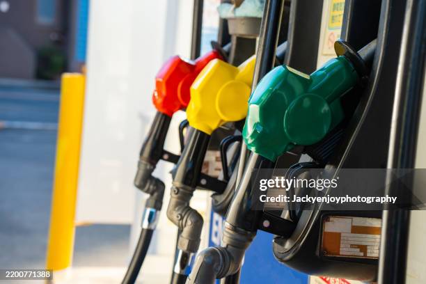 close-up of the petrol station's gasoline pumps and fuel nozzles - tanken stock-fotos und bilder
