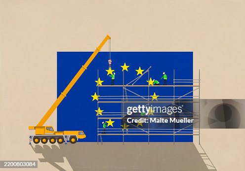 Crane and construction workers on scaffolding assembling European Union flag Crane and construction workers on scaffolding assembling European Union flag