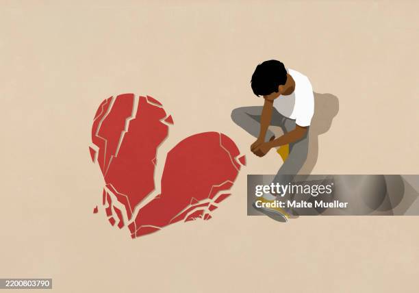 high angle view sad man looking down at broken heart - introspection stock illustrations
