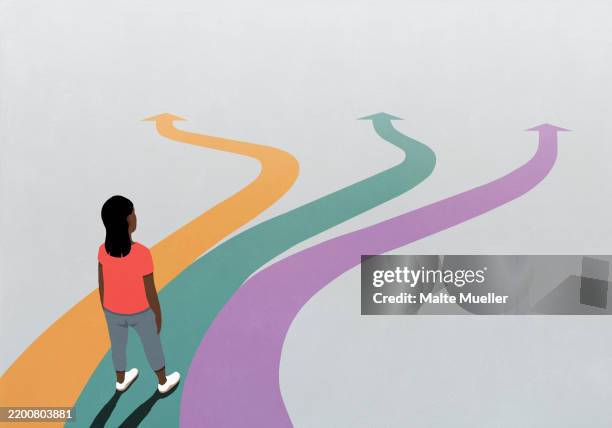 woman looking down at multicolored arrow paths extending in front of her - uncertainty stock illustrations