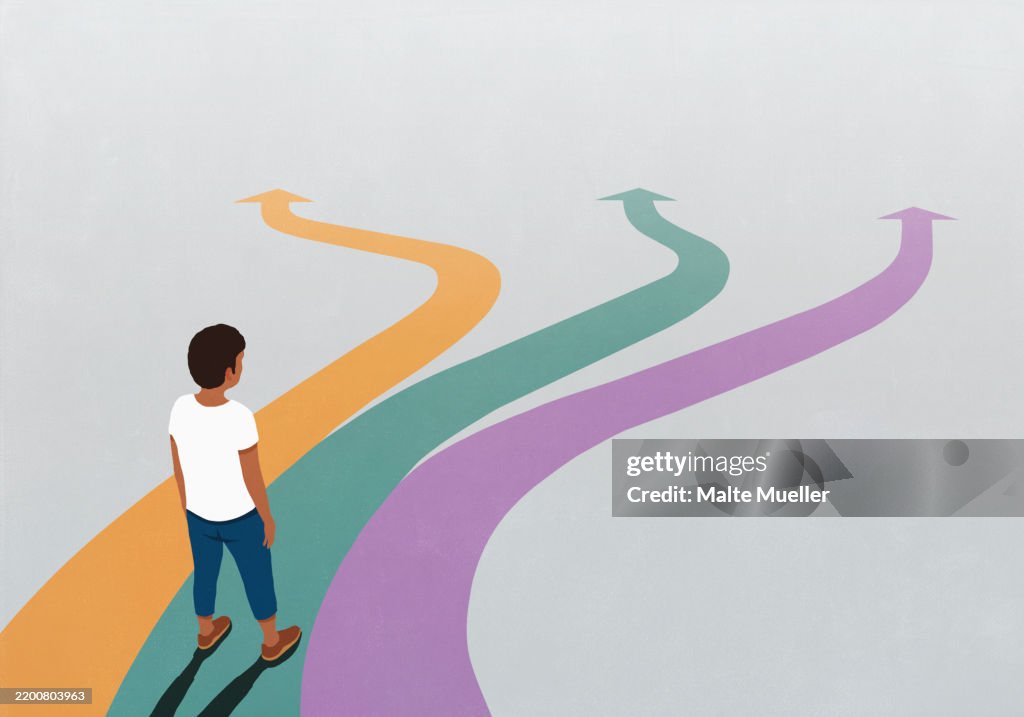 Man looking down at three multicolored arrow paths spreading before him