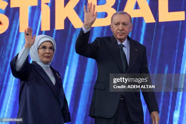 Turkey's President Recep Tayyip Erdogan and his wife Emine Erdogan wave to supporters as they arrive to attend the Justice and Development Party , as...