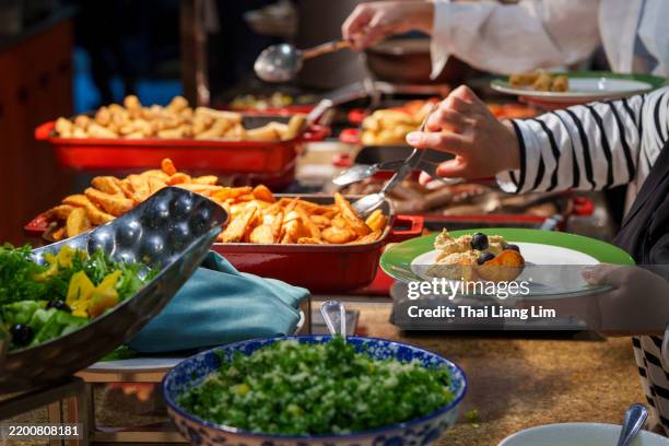 guests serving themselves at hotel buffet - buffet stock pictures, royalty-free photos & images
