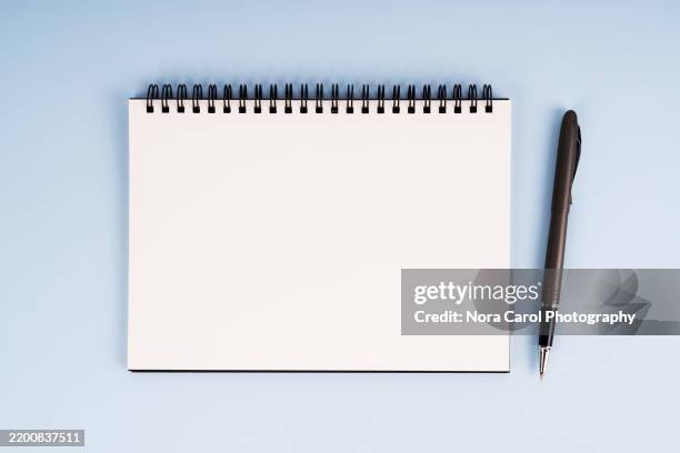 blank notepad and pen on blue background - bloco espiral imagens e fotografias de stock