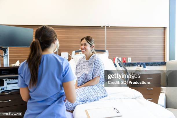 paziente felice che parla con il medico donna nella stanza d'ospedale - rapporto medico paziente foto e immagini stock